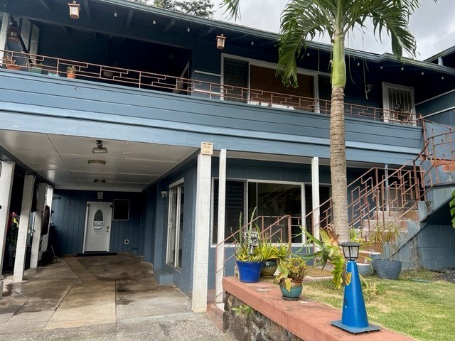 A blue building with a palm tree in front.